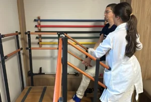 Paciente com esclerose múltipla sendo acompanhado por equipe multidisciplinar em reabilitação